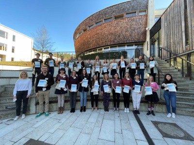 A group of young scholarship holders hold certificates in their hands