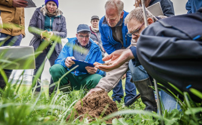 A person explains something to interested parties in a field.