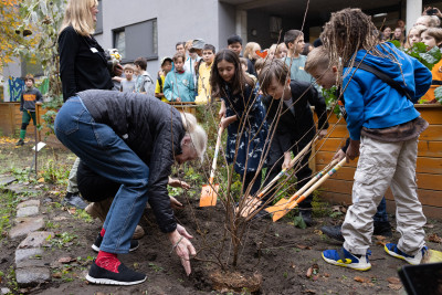 Jane Goodall plants a tree together with children