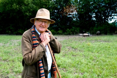 Hans-Günther Kaufmann is standing in a field, leaning on a stick